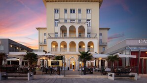 A hotel with a central courtyard, multiple balconies, and outdoor seating areas. - BO Hotel Palazzo (Porec)