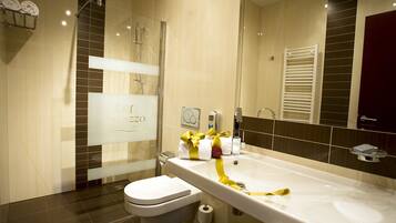 A modern bathroom with a bathtub, toilet, and shower.