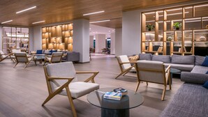A modern interior with wooden flooring, contemporary furniture, and built-in shelving with plants. - Mitsis Rodos Village (Rhodes)