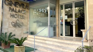 Exterior del Hotel Ginevra Palace, con un diseño moderno, que destaca una entrada principal con puertas de cristal y una escalera que conduce a ella.