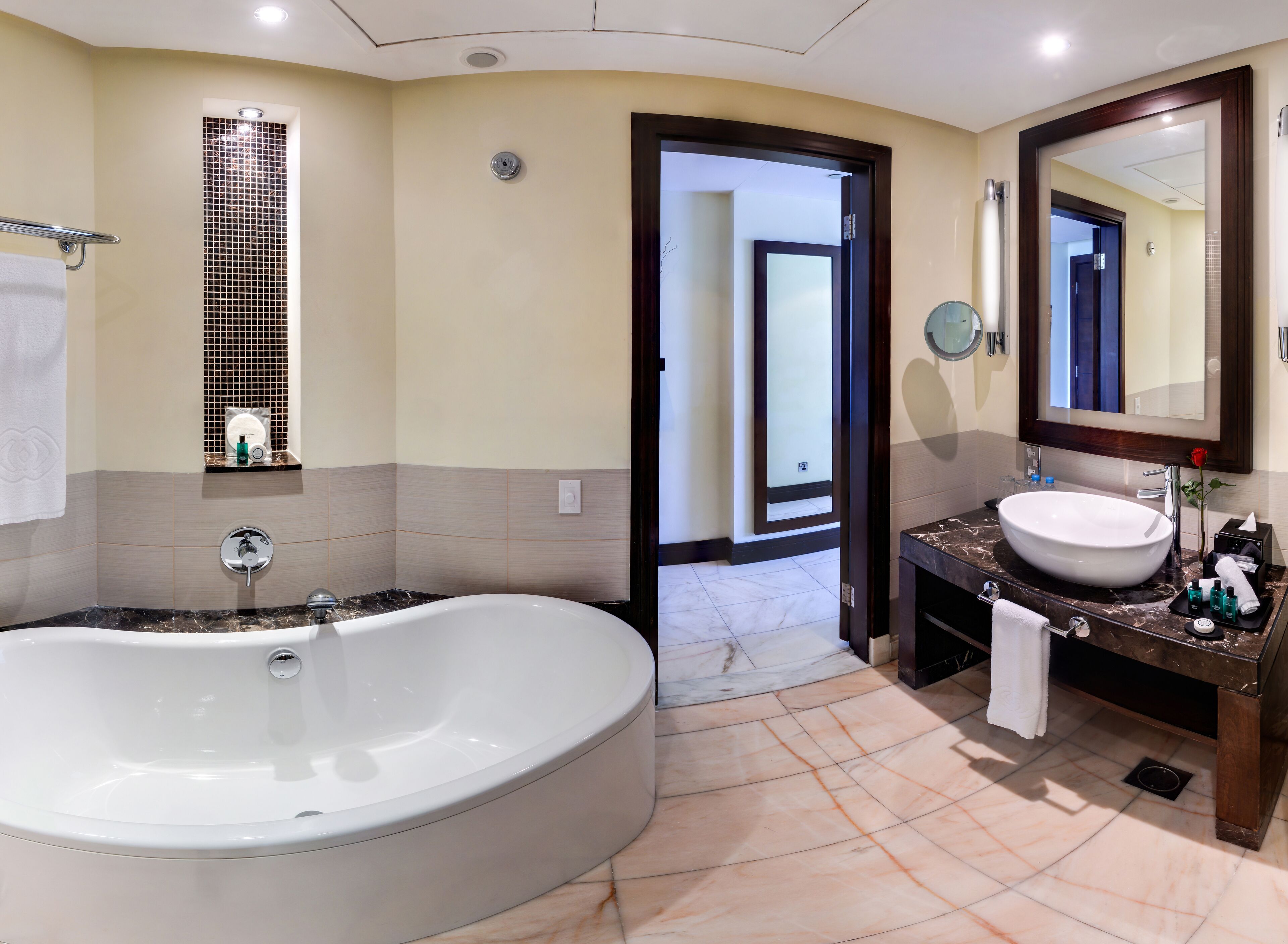 Un baño moderno con una bañera grande, un lavabo y un espejo.