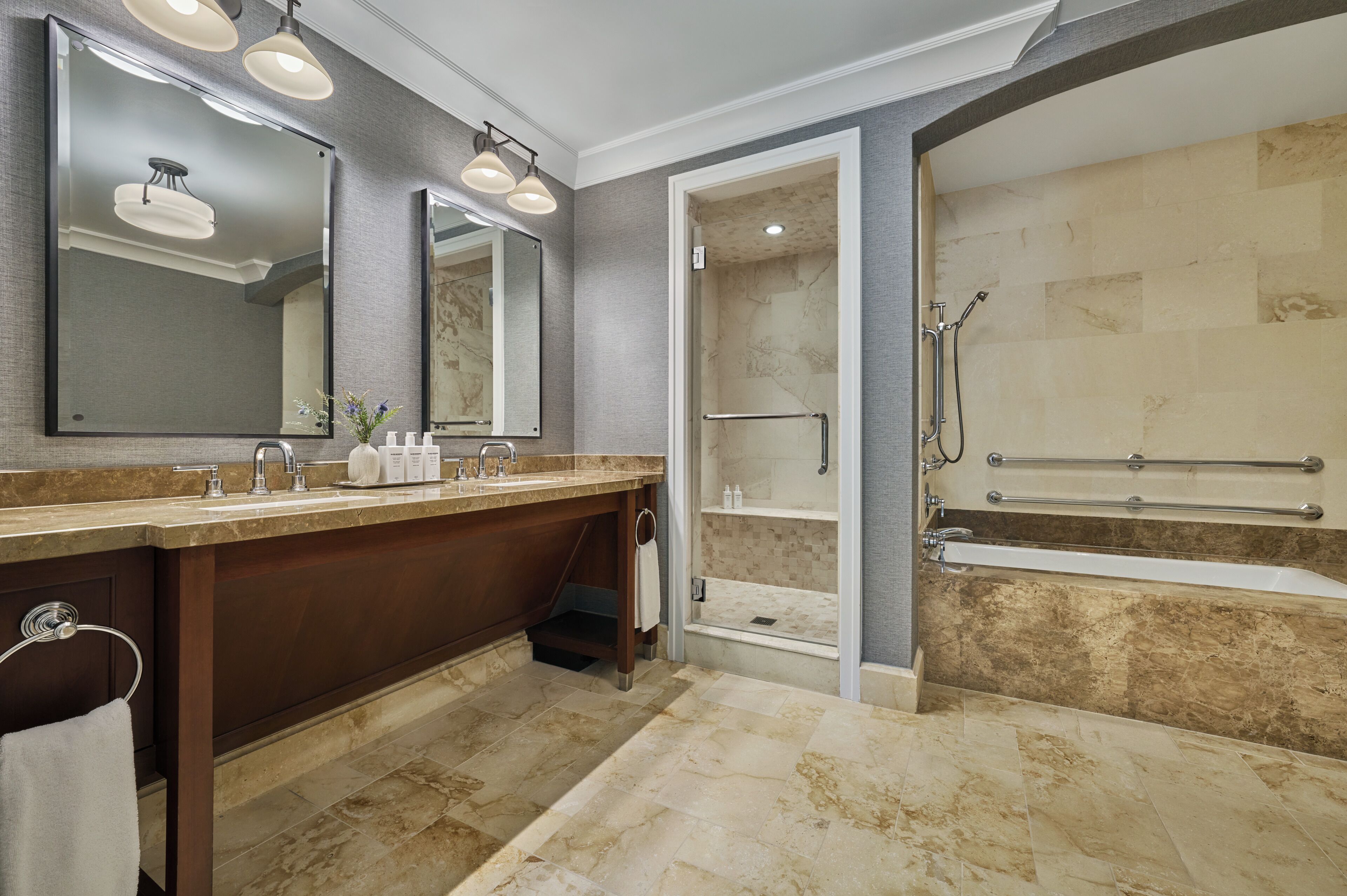 A modern bathroom with a large vanity, a walk-in shower, and a bathtub.