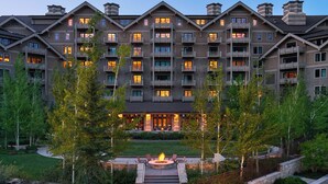 A multi-story hotel with a central courtyard, outdoor seating, and a fire feature.