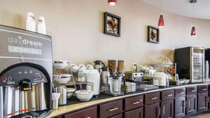 Una zona de cafè amb una màquina de cafè Daydream Blend, diversos utensilis per preparar cafè i un frigorífic ple de begudes.