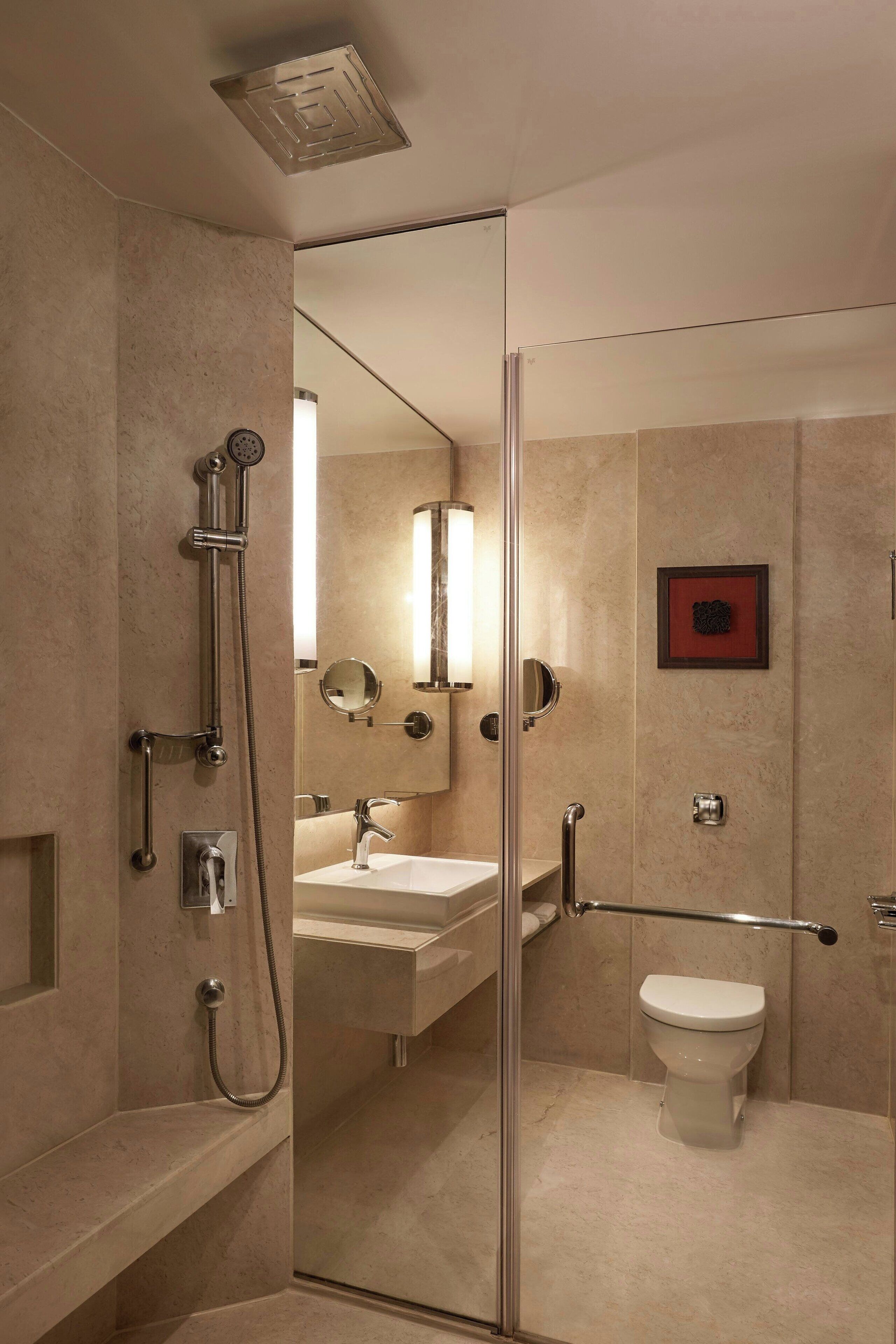 A modern bathroom with a glass shower enclosure, a toilet, and a sink with a mirror.