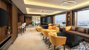 A modern hotel lobby with a large sofa, chairs, a coffee table, and a TV. - Courtyard by Marriott Mumbai International Airport (Mumbai)