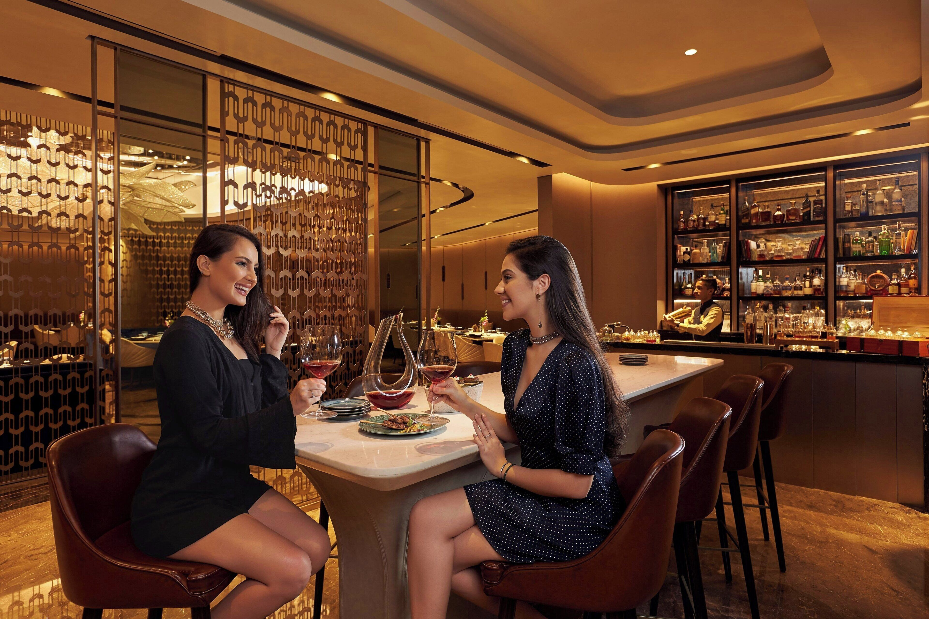 A bar area with a wine display and seating.