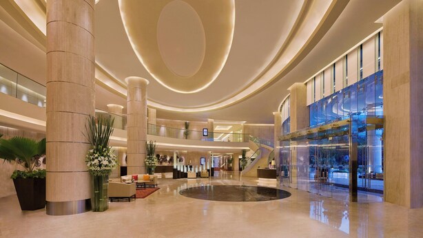 A spacious lobby with high ceilings, large columns, and a central atrium. - Courtyard by Marriott Mumbai International Airport (Mumbai)