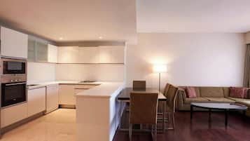 Una cocina moderna con electrodomésticos integrados y un comedor con sofá y mesa.