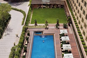 A rooftop pool with surrounding lounge chairs and a well-maintained lawn. - Courtyard by Marriott Mumbai International Airport (Mumbai)