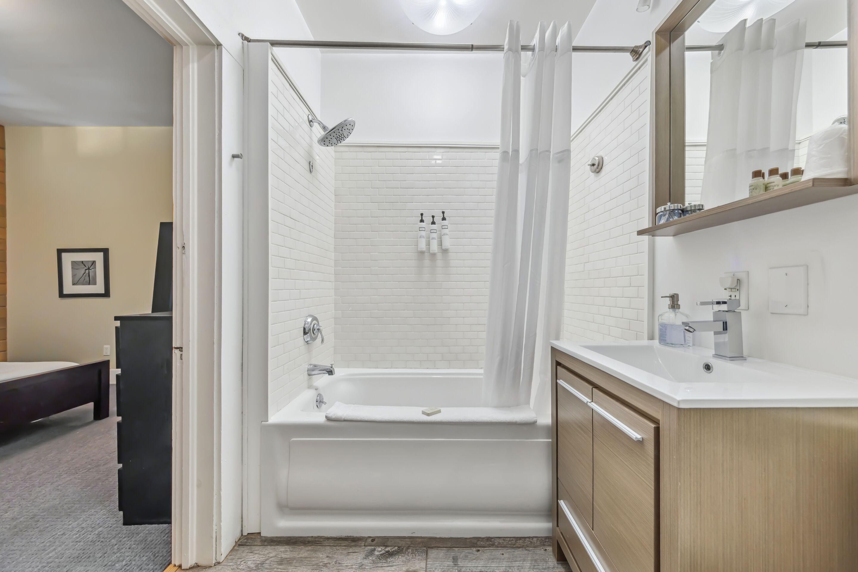 A modern bathroom with a bathtub, shower, and vanity.