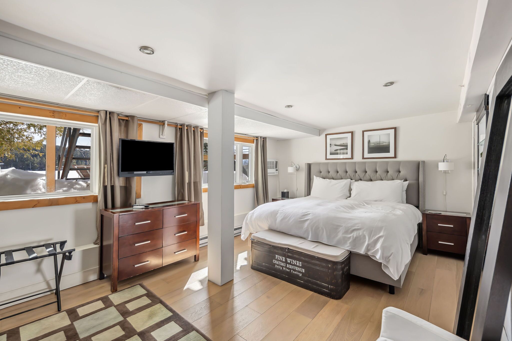 Een moderne slaapkamer met een groot bed, een televisie en een dressoir.