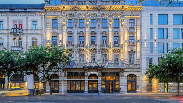 Un edificio histórico con arquitectura ornamentada, ventanas grandes y una entrada destacada que dice "Courtyard".
