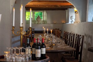 A dining table set with wine bottles and glasses, candles, and classical decor. - Store Restrup Slotshotel (Nibe)