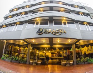 The exterior of the Paraona Grand Hotel with a modern design, featuring multiple balconies and a well-lit entrance.