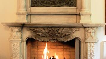Una chimenea con elaboradas tallas y fuego encendido.