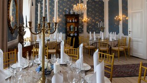 A formal dining room with a chandelier, ornate mirror, and a china cabinet.
