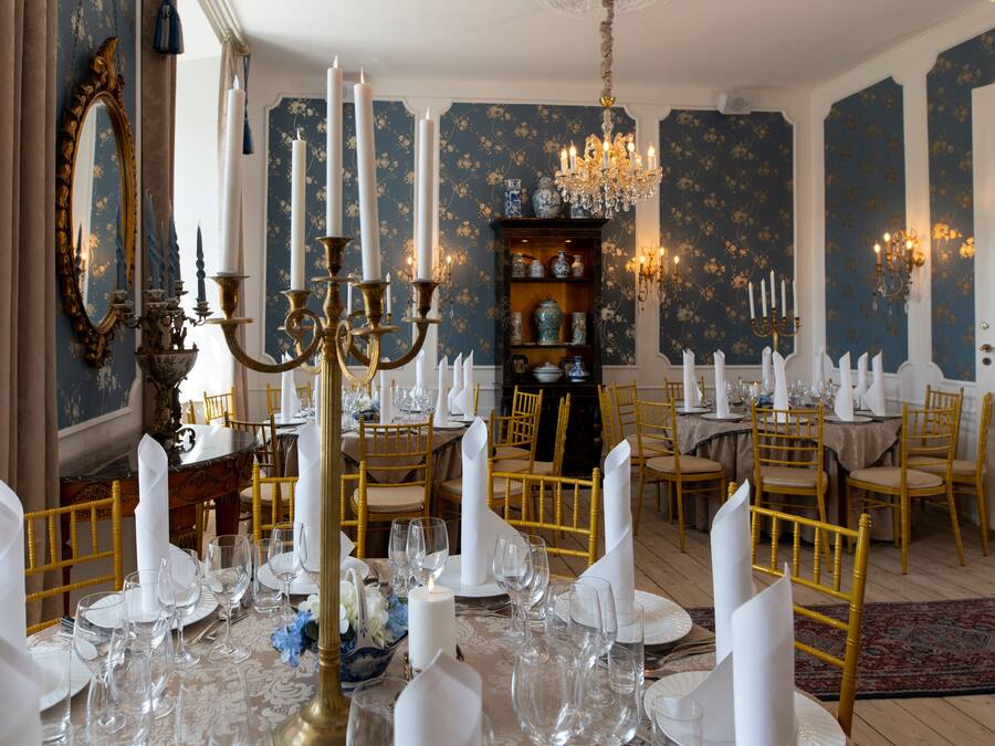 A formal dining room with a chandelier, ornate mirror, and a china cabinet.