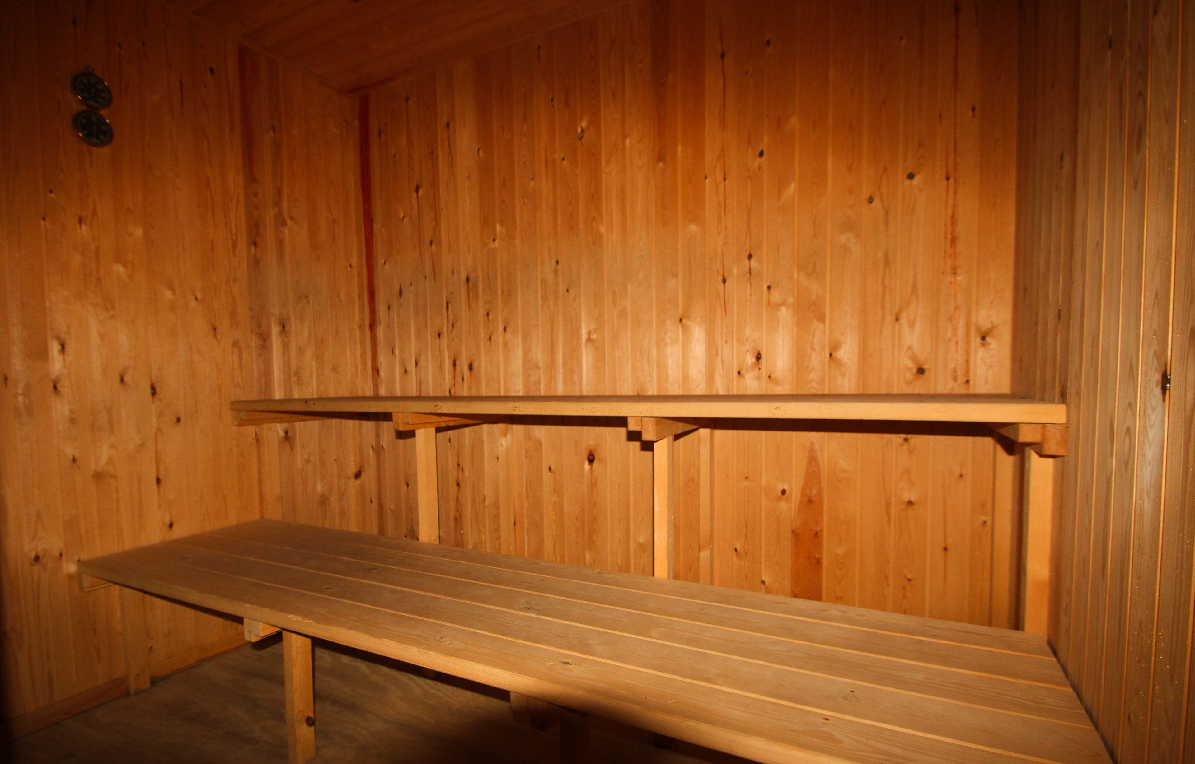 Un sauna en bois, doté de bancs et d’une banquette.