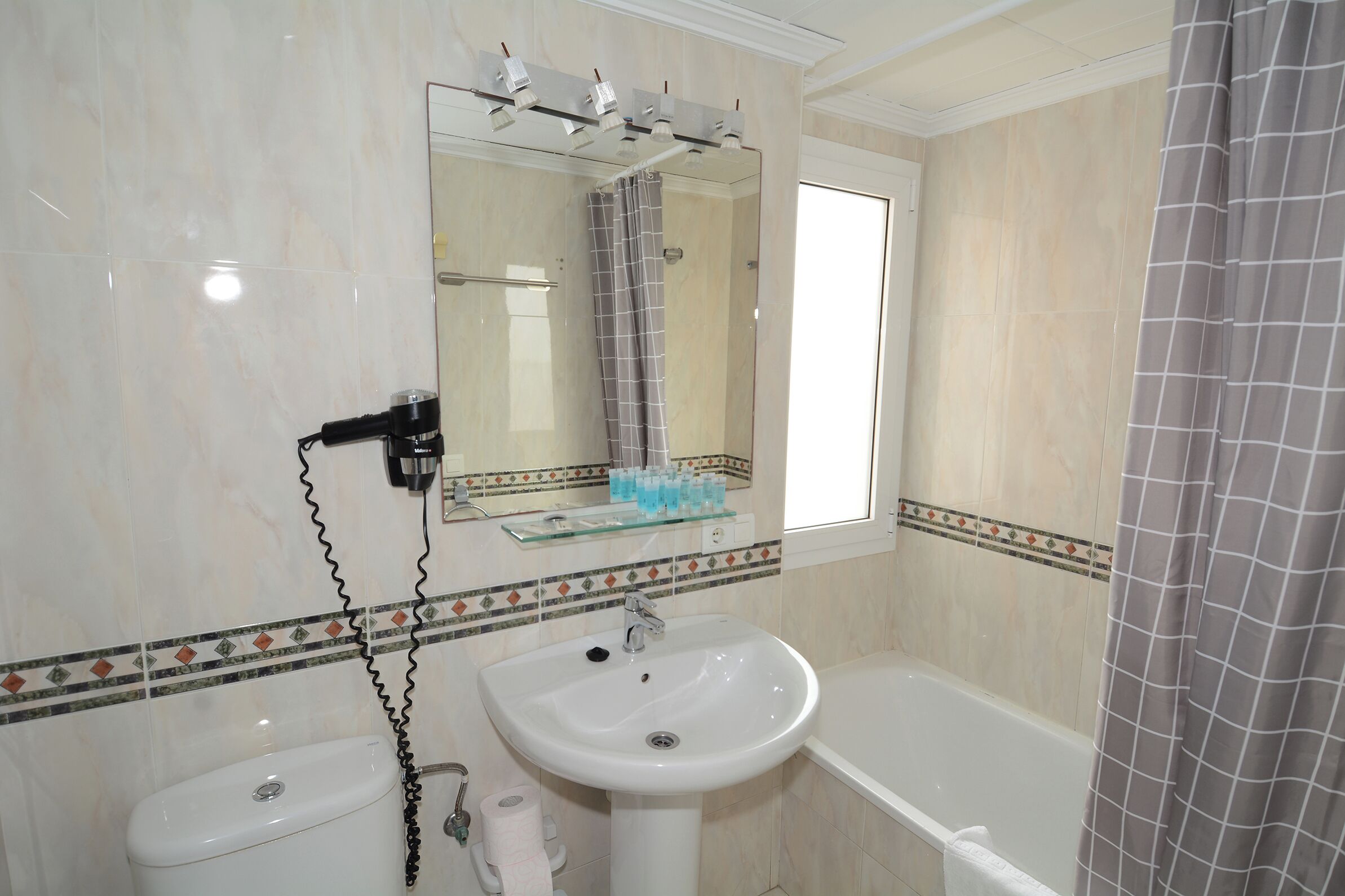 Un baño con inodoro, lavabo y bañera.