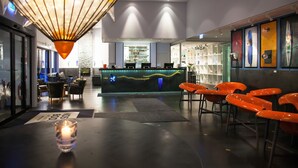 Un área de bar moderna con mostrador, asientos y una lámpara decorativa.