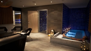 Un área de spa con un jacuzzi, sillones reclinables y una pared de azulejos.