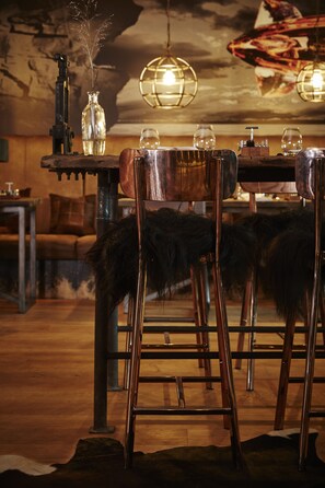A rustic interior with wooden furniture, a chandelier, and a vintage-style wall.