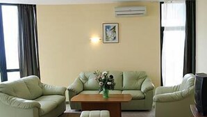 A living room with a sofa set, a coffee table, and a television. - Palm Beach (Varna)