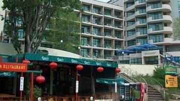 Een meerlaags hotel met een restaurant op de begane grond.