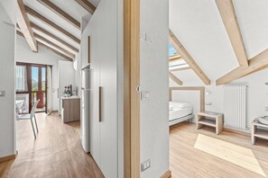 A modern interior with a kitchen, dining area, and bedroom. - Aparthotel Des Alpes (Cavalese)