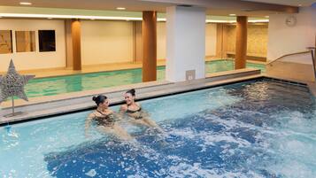 An indoor swimming pool with clear water, a star-shaped decoration, and a clock on the wall.