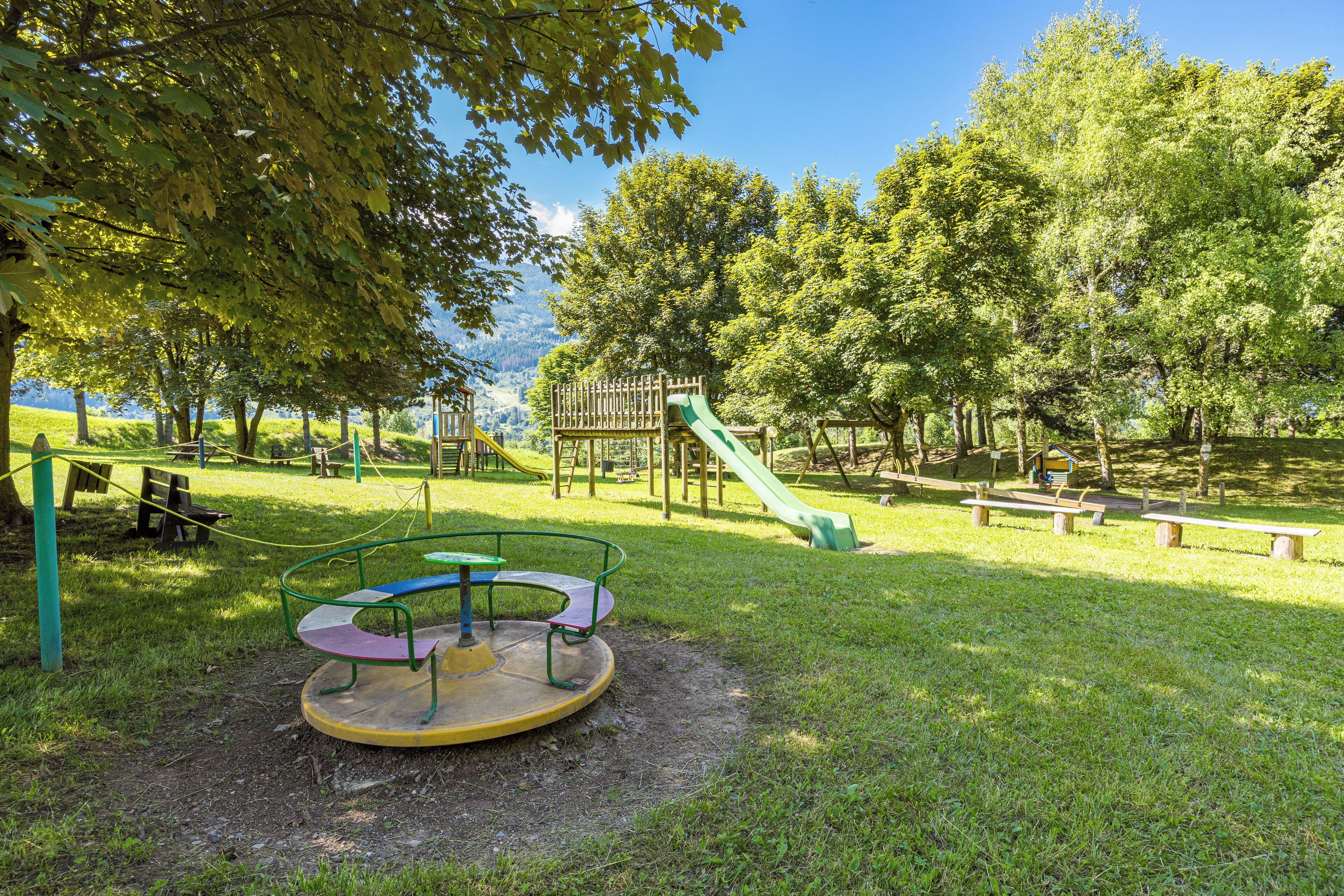 Un parc infantil amb una catàfora, tobogans i taules de picnic.
