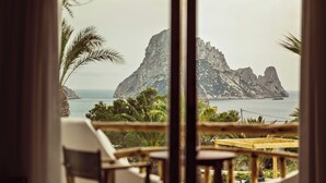 A balcony with a view of a rocky island and the sea. - Petunia Ibiza, a Beaumier Hotel (Sant Josep de sa Talaia)