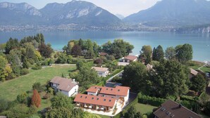 Un quartier résidentiel avec des maisons, un lac et des montagnes en arrière-plan.