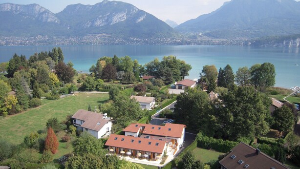 Zona residencial con casas, un lago y montañas al fondo.