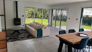 Una sala moderna con sofá, mesa de comedor y chimenea.