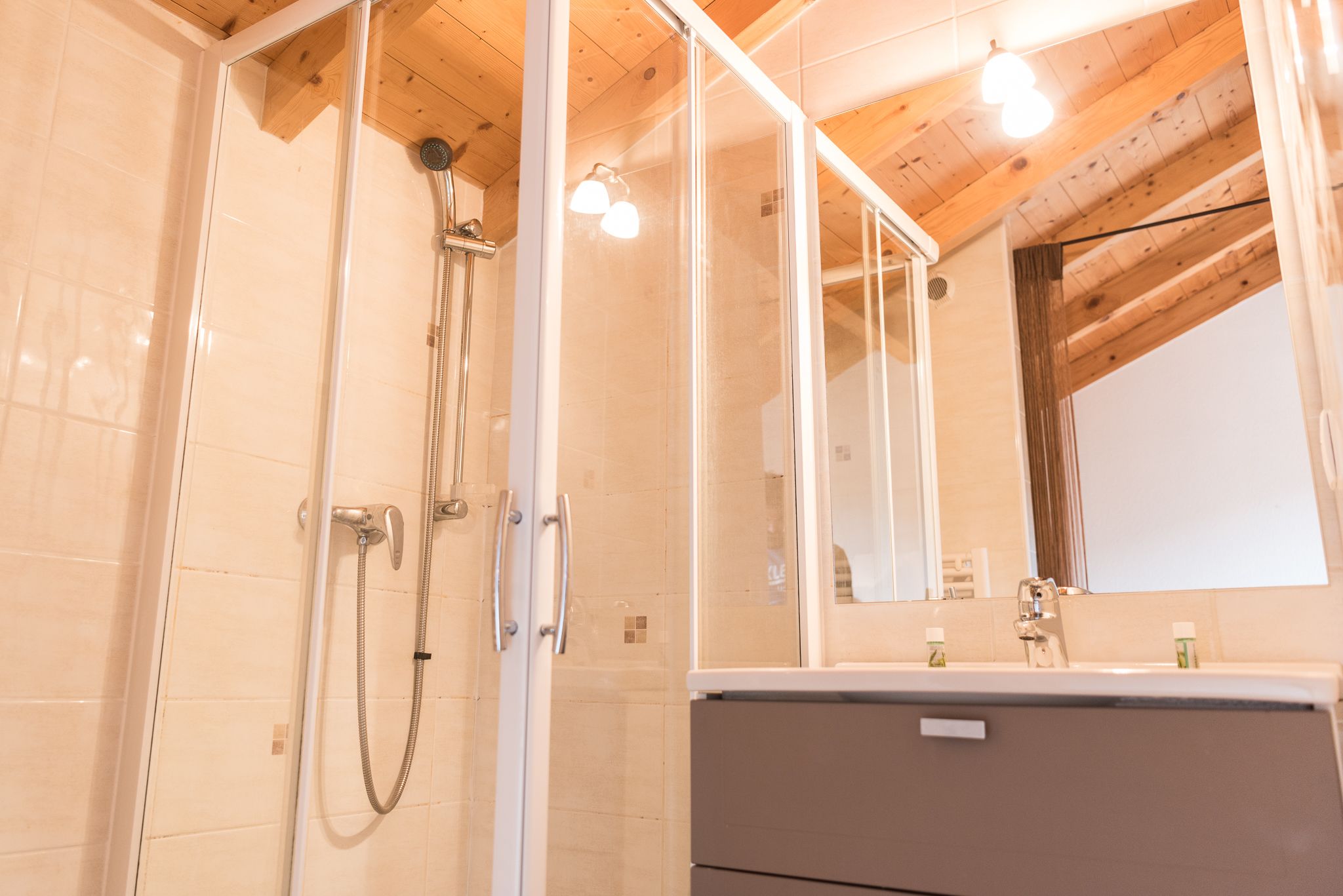 A bathroom with a shower, a mirror, and a vanity.