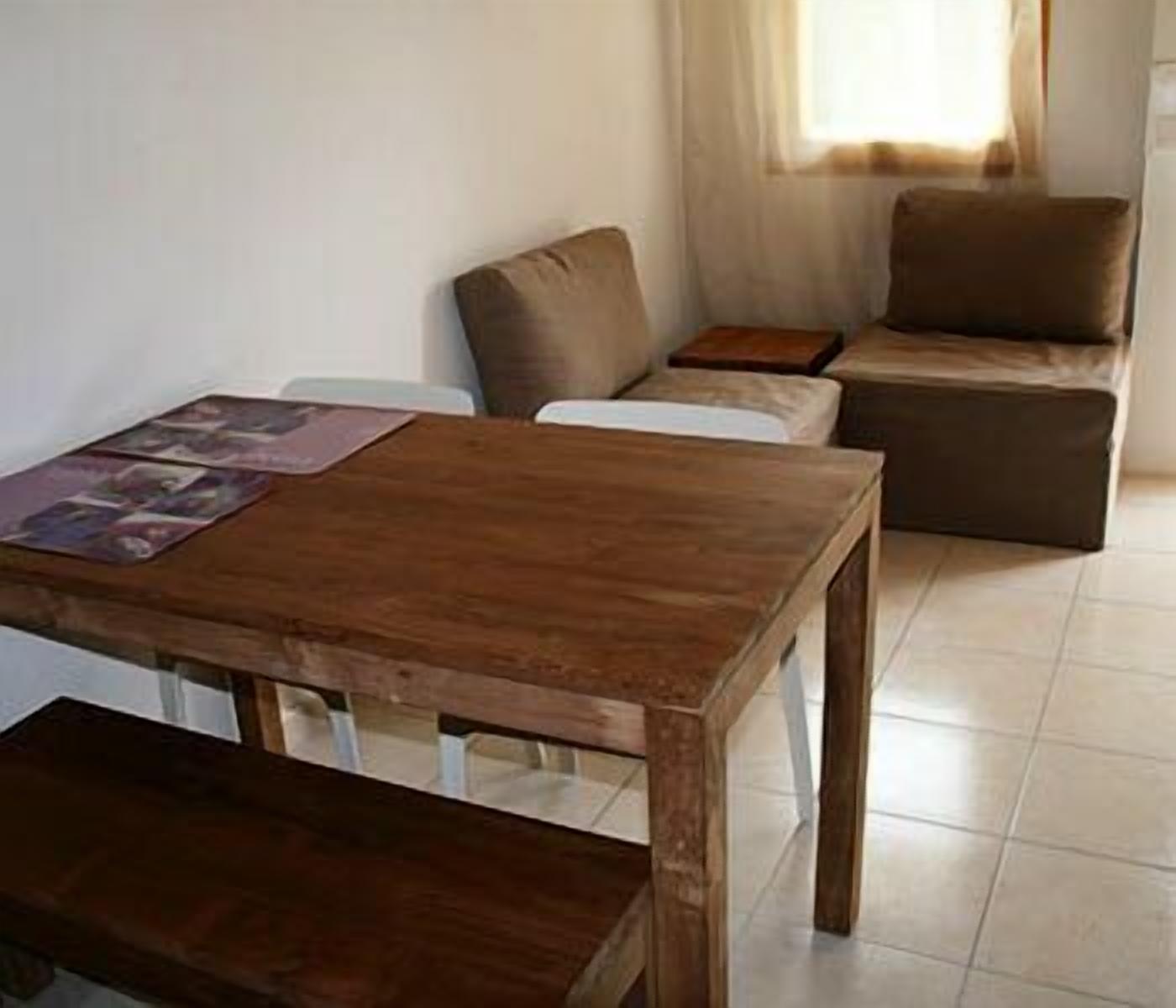 A room with a wooden table, a sofa, and a small side table.