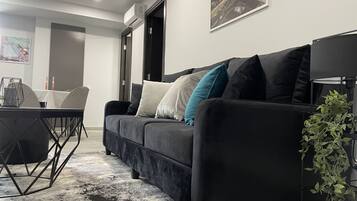 Suite Grand | Área de sala de estar | Smart TV de 40 pulgadas con canales por cable y televisión