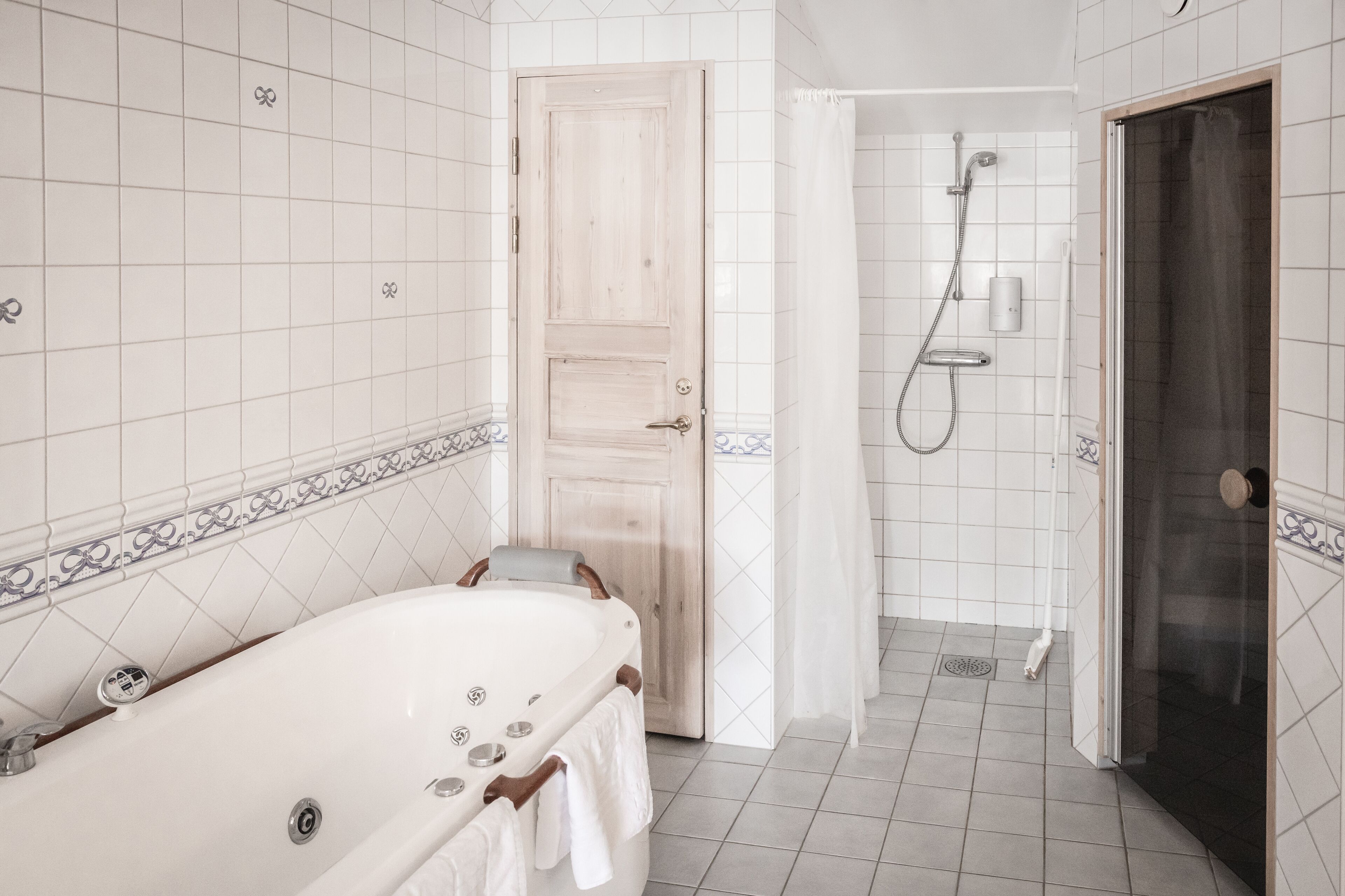 Un baño con bañera, ducha y paredes de azulejos.