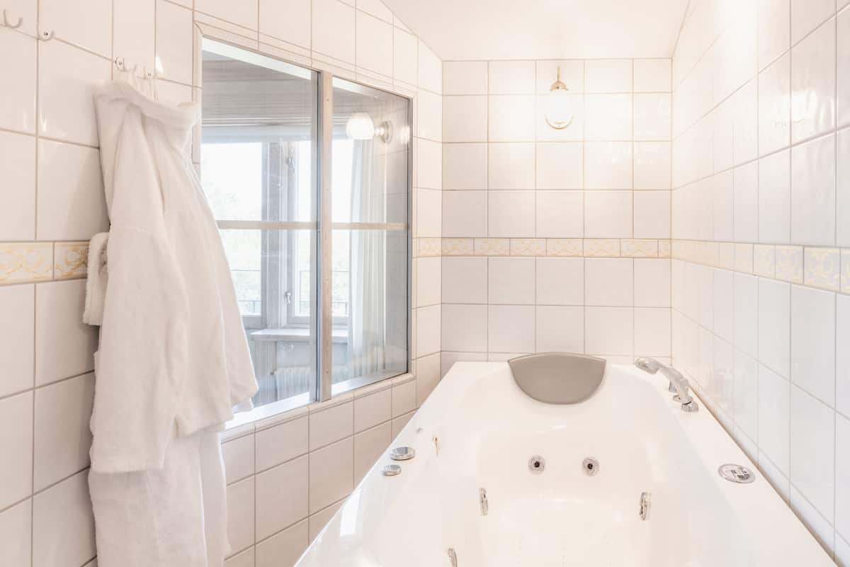 deluxe double room, jetted tub | bathroom | hair dryer, towels
