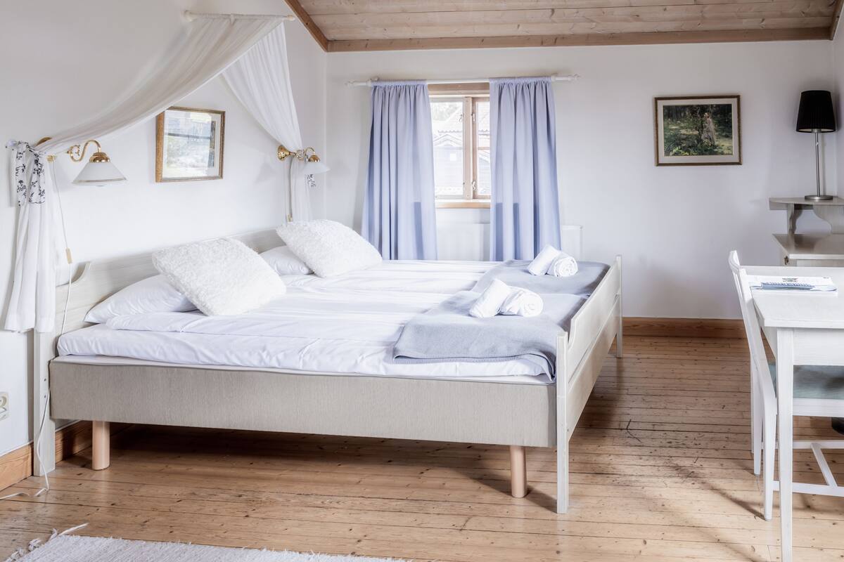 A bedroom with a bed, a desk, and a chair.