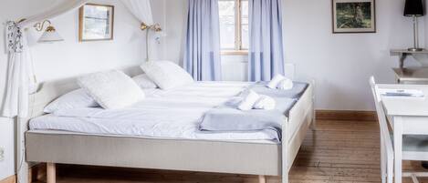 A bedroom with a bed, a desk, and a chair.