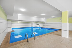 Una piscina techada, sillones reclinables de piscina