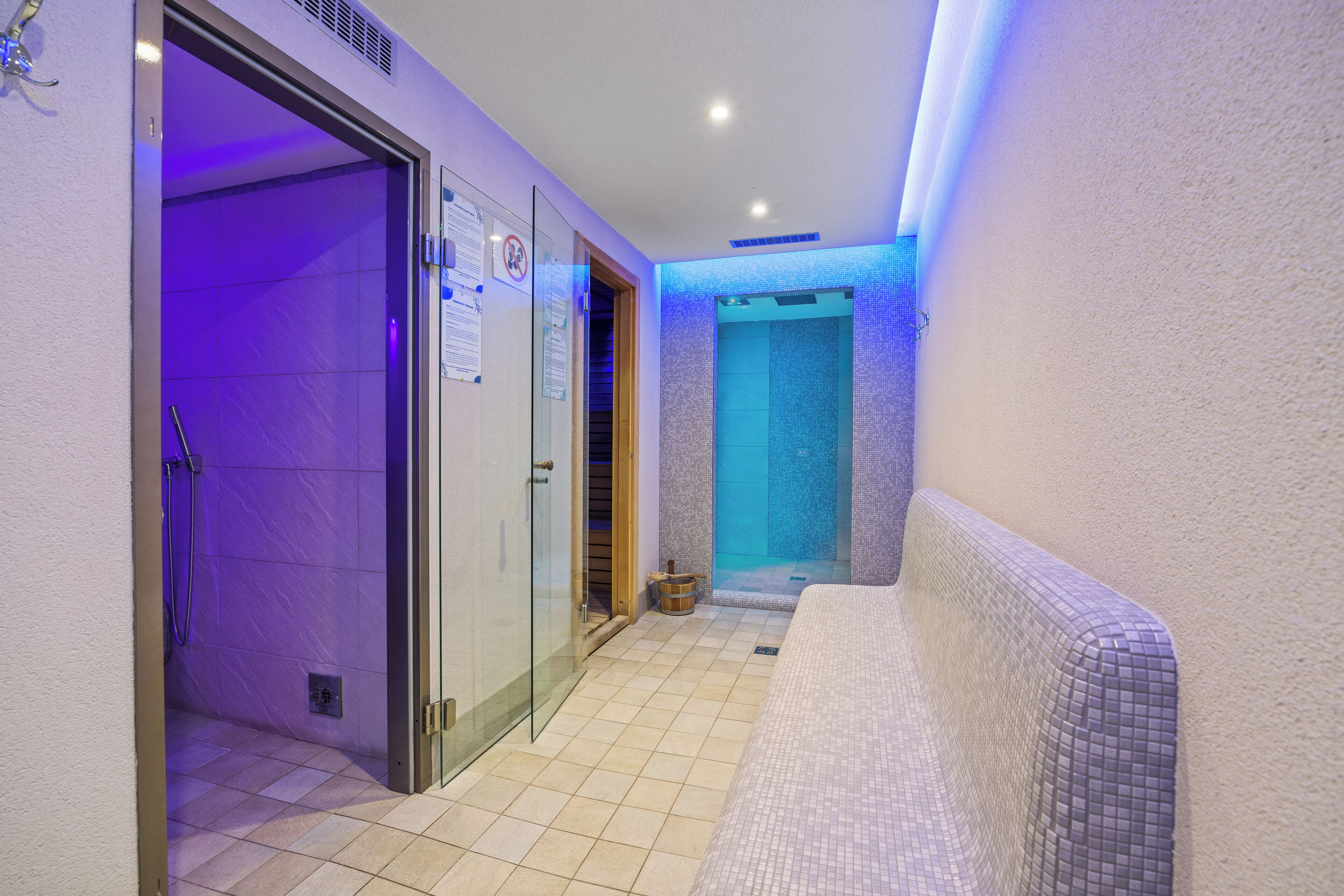 Un baño moderno con cabina de ducha de vidrio, bañera y suelo de baldosas.