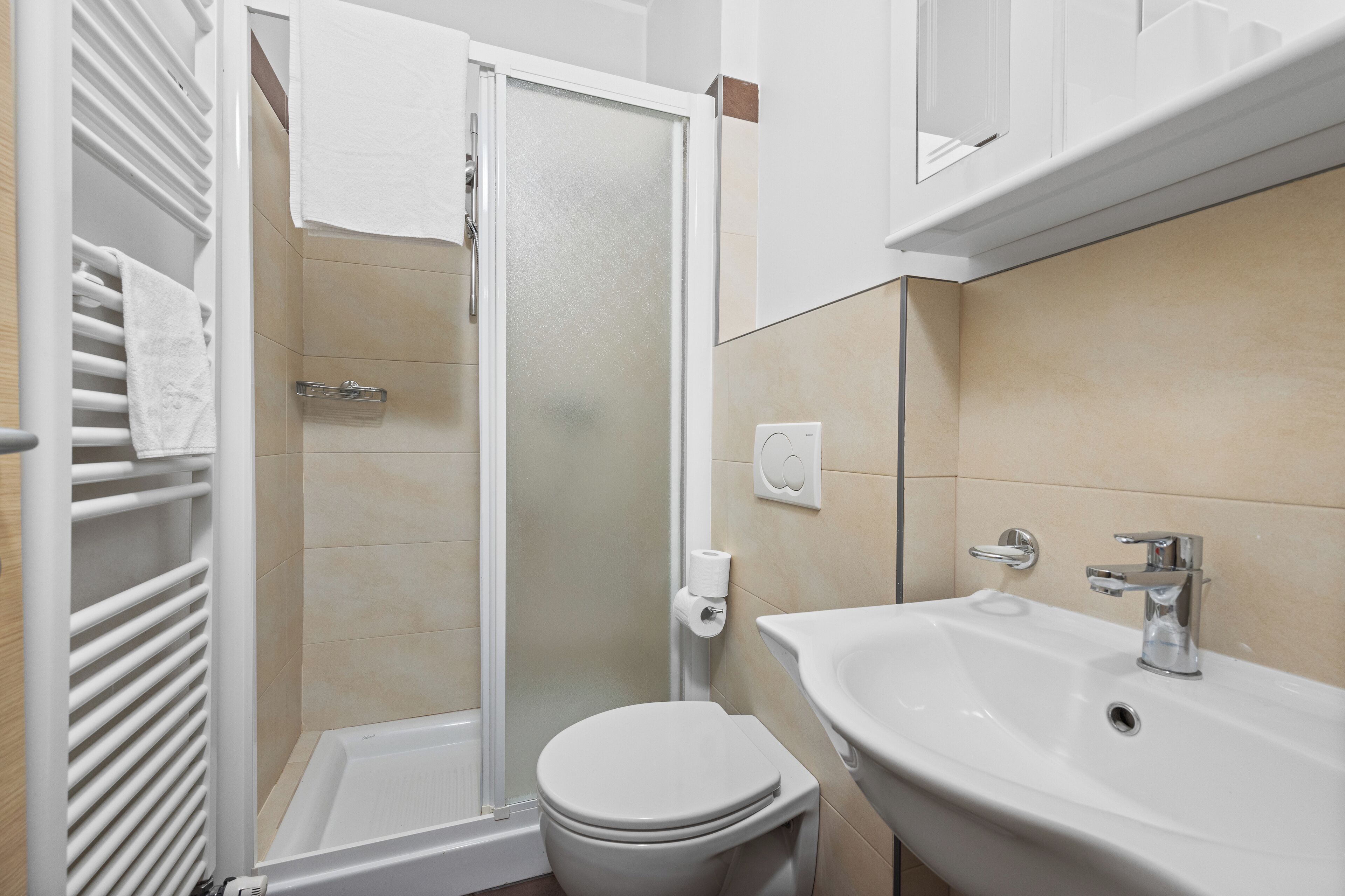 A bathroom with a shower, toilet, and sink.