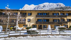 A multi-story hotel with balconies and a mountain backdrop. - Residence Lagorai (Tesero)