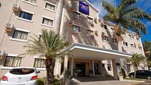 Un hotel con fachada plana, numerosas ventanas y un llamativo logotipo FENIX.