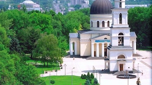 A church with a prominent dome and bell tower, surrounded by greenery and a cityscape in the background. - Mercure Chisinau Center Jazz Hotel (Chisinau)