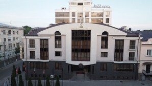 En moderne bygning med en stor buegang og skiltet "JAZZ HOTEL" over døren.